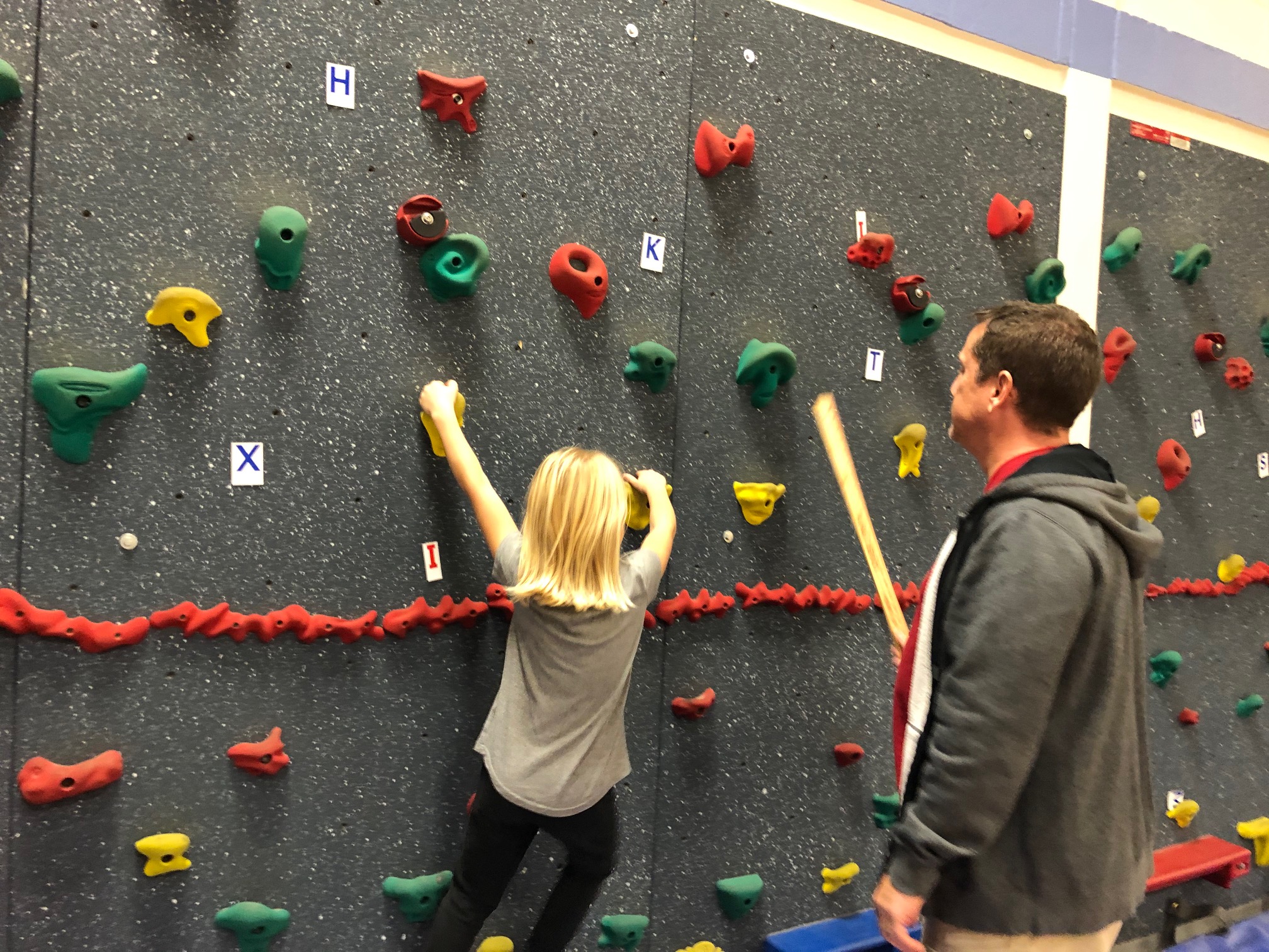 student rock climbing in gym class